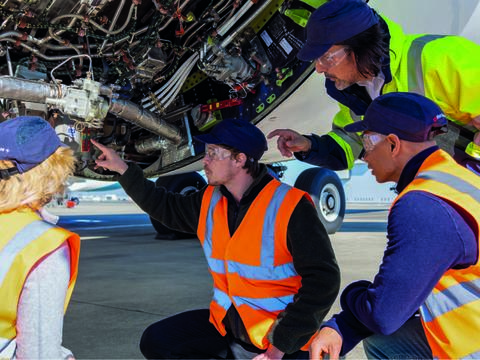 Maintenance training in action with mechanics in safety vests and goggles detecting and inspecting aircraft components