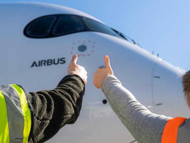 Airbus maintenance people on ground with thumbs up