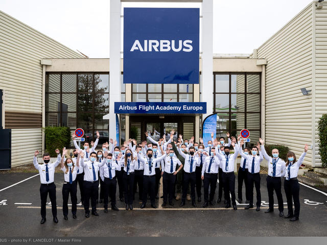 Airbus Flight Academy - cadets in front of building hands in the air