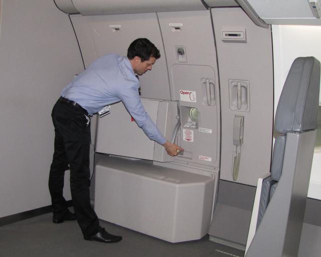 Cabin Crew Extended Training A cabin crew member in uniform closing the door of the aircraft.