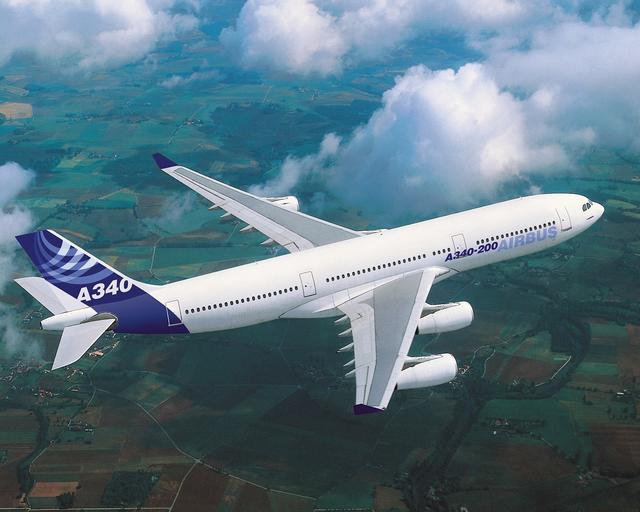 A340 in flight over fields, with Airbus livery