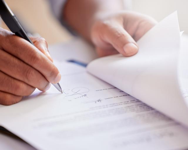 hands, signature and writing on a contract