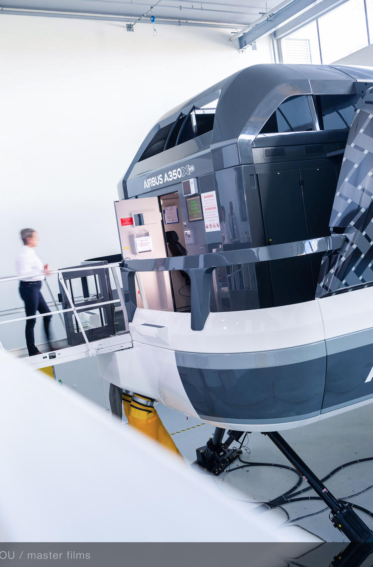 Pilot trainees stepping into a full flight simulator as part of their flight training course.