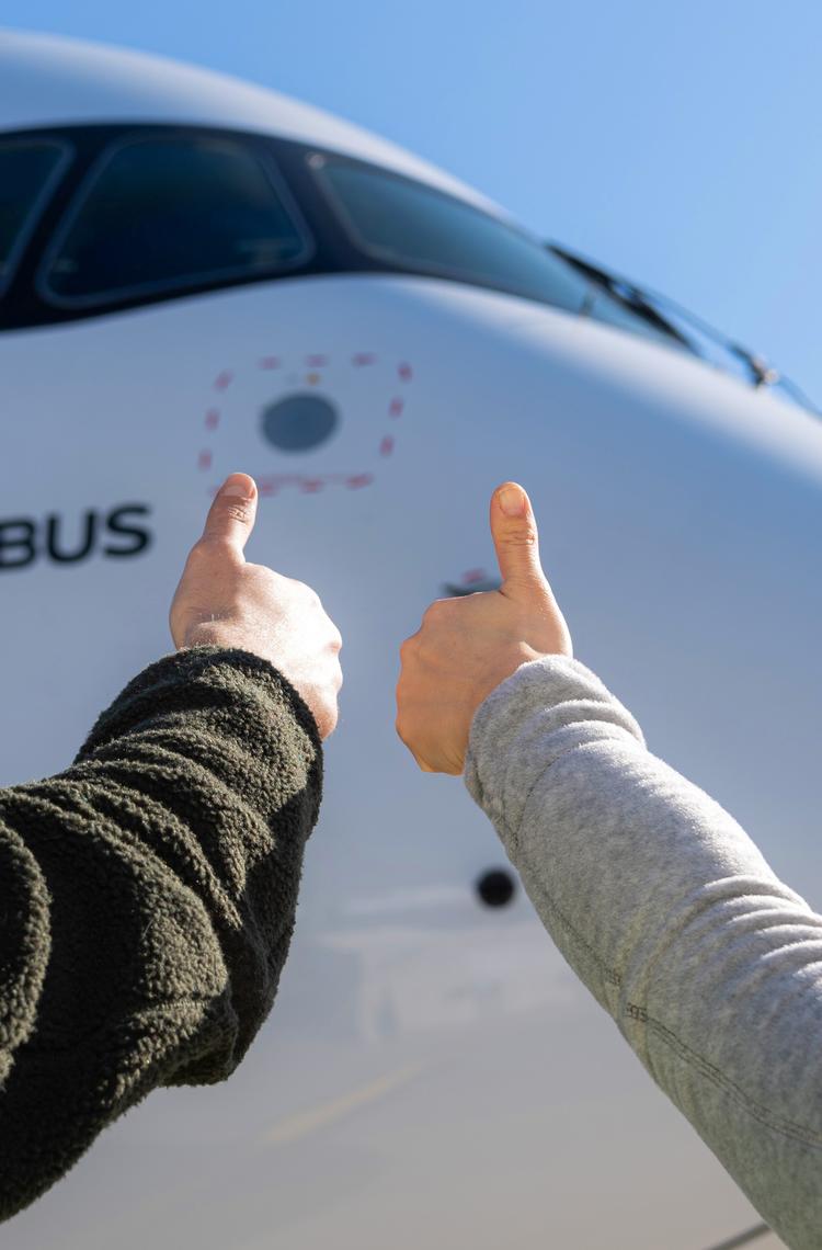 Airbus maintenance people on ground with thumbs up