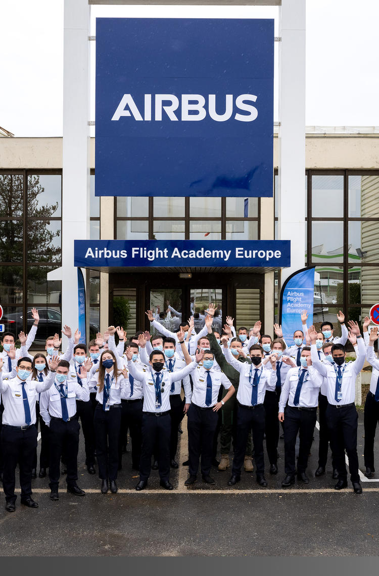 Airbus Flight Academy - cadets in front of building hands in the air Airbus Flight Academy - cadets in front of building hands in the air