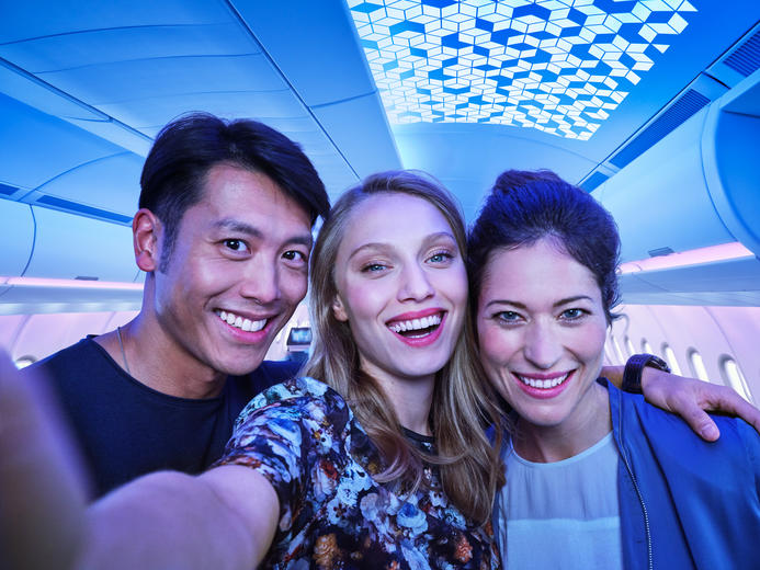 Three people taking a selfie in an airspace cabin