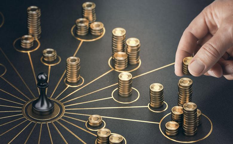 A man places gold coins on a table representing multiple income streams.