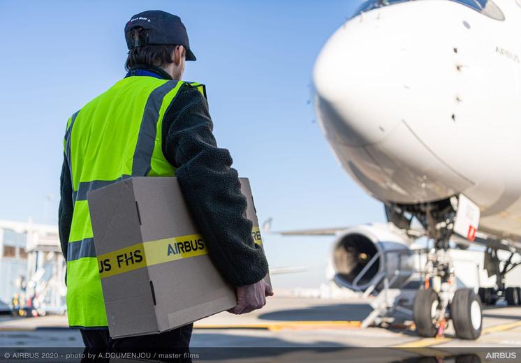 Man carrying a box towards an Airbus aircraft